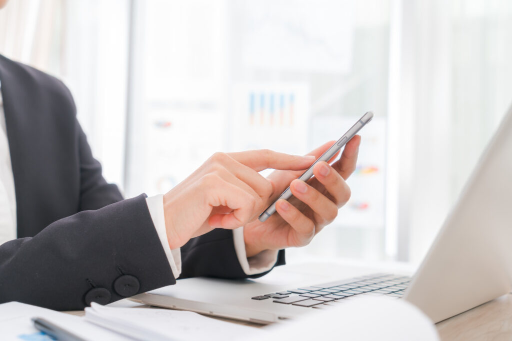 Aware Insurance Services business person scrolling on a cell phone